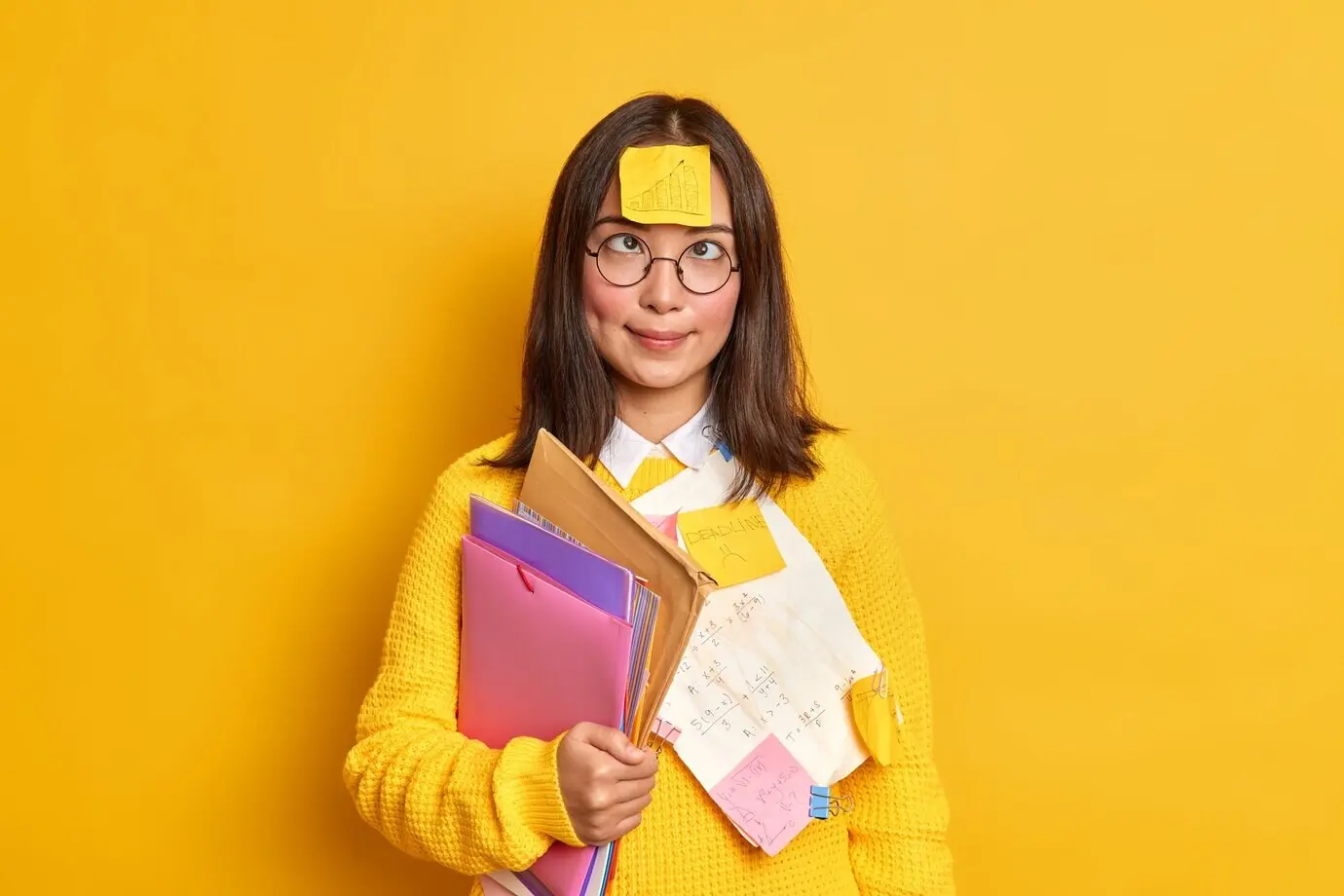 Забавная и умная девушка-ботаник сводит глаза к переносице, на лбу у неё наклейка с нарисованным графиком.